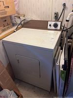 Full view of the automatic clothes dryer showing white body and front door.