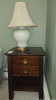 Front view of the dark wood nightstand with two drawers and open shelf, nightstand showing brass pulls and wood grain.