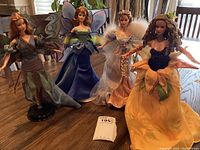 Photo showing all four fairy Barbie dolls together on a table, displaying their different outfits and wings.