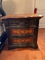 Straight-on front view of chest showing three serpentine-front drawers with ring pull and bail handles