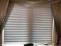 Hunter Douglas blind fully lowered and closed with neutral pleated fabric.