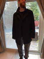 Front view of black cashmere coat on model showing button closure and collar