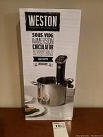 Front of the original product box showing the Weston Sous Vide Immersion Circulator in a pot, branding, and wattage.