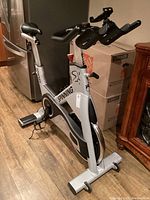 Front-left angled view showing entire bike frame, stabilizer feet and surroundings