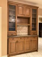 Front view of closed cabinet showing door configuration, granite countertop and backsplash tile pattern
