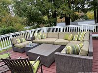 Full view of L-shaped sectional with chair and tables on deck