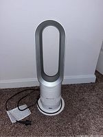 Full front view of Dyson Hot+Cool bladeless tower fan heater on carpet