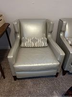 Front view of silver wingback armchair with accent pillow