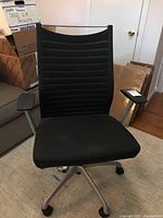 Front view of black office chair showing fabric seat and mesh backrest with horizontal stripes.