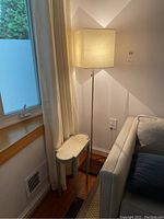 Side table and lamp corner setup beside window and sofa, showing size and placement.