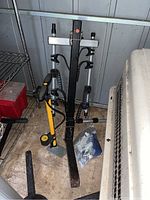 Thule bike rack and JoeBlow pump upright on floor showing bike rack arms and pump handle