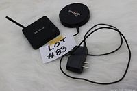 Photo of MyGica and Livebox Android TV boxes side by side with lot number card visible.