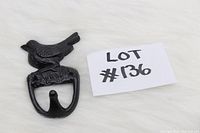Black cast iron wall hook with bird design, displayed with lot number card.