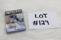 Stack of hockey cards featuring Wayne Gretzky, wrapped in plastic, with visible front card showing Gretzky in Edmonton Oilers jersey.