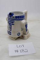 Side angle view of R2D2 mug showing dome top, front detailing, and one leg base.