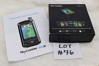 SkyCaddie SGX User Guide booklet beside original box with colorful golf maps on the cover.