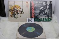 Front covers of Chicago Greatest Hits and The Clash London Calling vinyl records with a vinyl record in an outer sleeve placed below them.