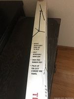Photo of the original box showing product details and branding of the tripod boom microphone stand.