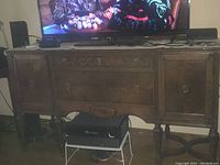 Samsung 55 inch LED TV on vintage wooden stand showing a scene from a movie with subtitles.