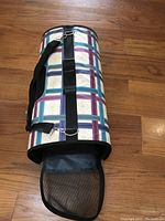 Photo of folded soft-sided pet carrier showing mesh ventilation and shoulder strap.