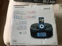 Photo of the Memorex Clock Radio for iPhones model MI4390BLK in its original box showing front packaging with product image and key features.