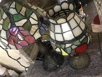 Photo showing vintage stained glass lamp with floral design and two stained glass flower candle holders on metal bases.