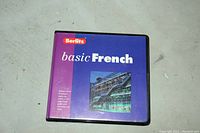 Front view of the closed oversized plastic case with the Berlitz basic French instructional booklet cover visible.