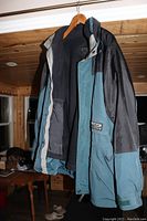 Front view of large Alpine Expedition winter coat on hanger, showing color, inside fleece lining and zippered front.