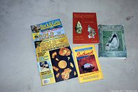 Photo of 5 publications laid out on a gray surface: 2 Gold Prospecting magazines, 2 rock and mineral books, and 1 Southwest travel guide book.
