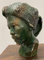 Front left profile of the carved verdite stone bust showing intricate facial features and textured headdress.