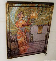 Front view of the gilt framed calendar with Art Nouveau woman blowing bubbles and year 1900 calendar grid.
