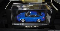 Front and side view of the blue Porsche 911 GT3 diecast car inside clear display box with black base