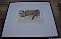 Front angled view of the framed art print showing the image of a house in snow and tree branches.