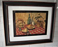 Framed watercolour painting showing the full still life composition with a red checkered tablecloth, bread, bottles, glass with butter, and potted plant.