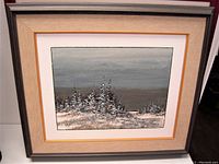 Framed impressionist oil painting showing snow-covered trees under a gray sky, double matted and framed.