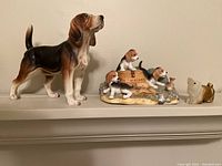 Photo of large standing beagle, puppy trio on Budweiser base, and two small dog figurines