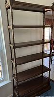 Full front view of six-tier open bookshelf with bottom drawer