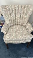 Front view of the Ethan Allen wing back chair showing its patterned upholstery and wooden legs.
