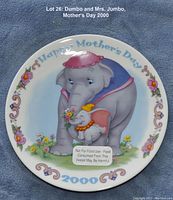 Photo of decorative plate featuring Dumbo and Mrs. Jumbo with Mother's Day 2000 theme, showing front view with artwork and border.