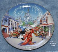 Collector plate showing Mickey Mouse in sorcerer robe and hat on Main Street USA with Cinderella Castle in background.