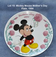 Photo of round white ceramic plate featuring Mickey Mouse holding a pink rose, surrounded by rose illustrations and 'Mother's Day 1994' text.