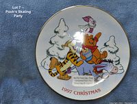 Front view of the collectible plate showing the colorful scene of Winnie the Pooh and friends skating and the wording '1997 Christmas' on the bottom rim.