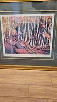 Full view of the framed art print showing autumnal birch trees over rocky ground in warm autumn colors.