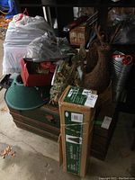 Boxed Christmas tree standing next to a plastic green tree stand and various decorations including a deer planter and wreaths.