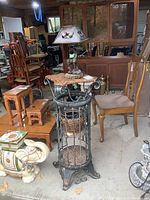 Round metal and wicker stand with two wicker shelves, closable gates on the front, and curling metal details on the top and bottom. Stand size 14x14x32 inches.