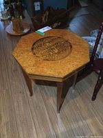 Side view of the octagonal wood table with detailed Florentine inlay top and tapered legs.