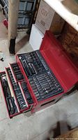 Overall view of the red Jobmate toolbox with multiple drawers open showing tool assortment inside