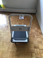 Front view showing the white handle frame and textured platform surface.