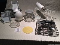 Wide view of all items including casserole dish, bowl, ramen bowl, utensil rack with utensils, cupboard shelf, sorting boxes, and drawer liner roll.