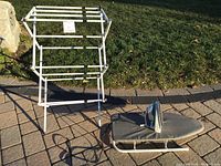 Full lot outdoors showing collapsible drying rack, tabletop ironing board with gray fabric cover, and Black & Decker iron resting on ironing board.